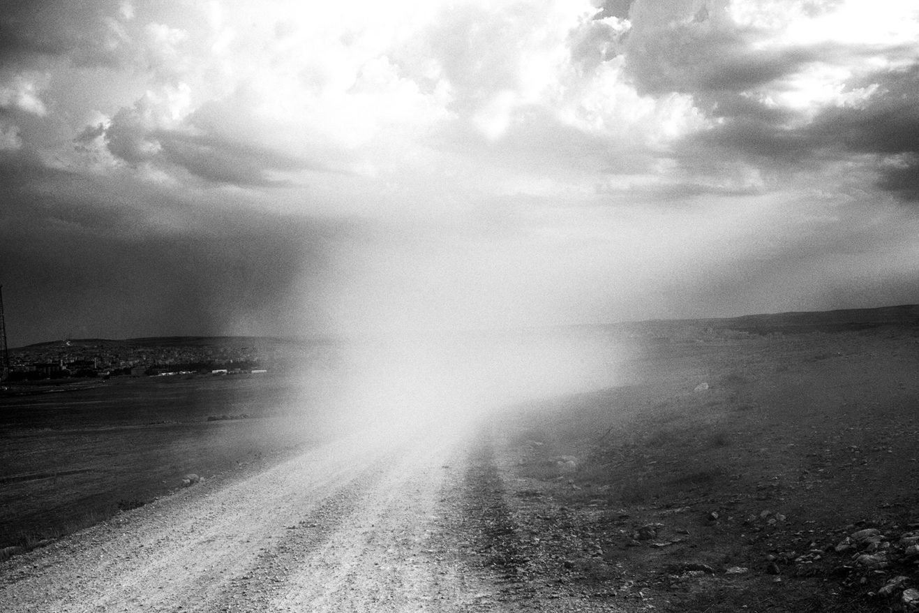 The dust of passing tanks on the road to Kobanî. The Republic of Turkey deployed tank battalions to the Syrian border. October 2, 2014. Suruç, Şanlıurfa, Turkey.