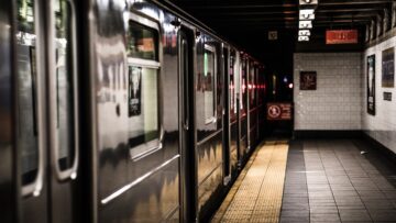 New York City train station with a train loading at the platform